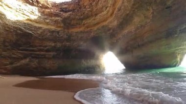 Portekiz 'in Algarve bölgesindeki ünlü Benagil Deniz Mağarası' nın nefes kesen iç manzarasında doğal tavan aralarından akan dramatik güneş ışınları, altın kum plajı ve turkuaz suları aydınlatıyor.