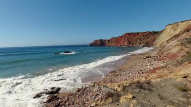 Şaşırtıcı okyanus dalgaları Portekiz 'in Algarve bölgesindeki Praia da Falesia' nın altın kıyılarına yuvarlanıyor. Belirgin kırmızı uçurum oluşumları ve gök mavisi Atlantik suları nefes kesici bir doğal manzara yaratıyor.