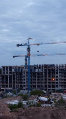 Gündüzün geceye geçişi olarak mavi kule vinci ile inşaat alanının görüntülerini kaydetme zamanı. Kentsel kalkınma projesi, gökyüzünün değişmesine karşı yerleşim yapısının ilerlediğini gösteriyor