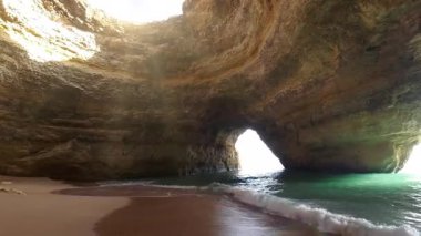 Portekiz 'in Algarve bölgesindeki ünlü Benagil Deniz Mağarası' nın nefes kesici manzarası doğal tavan aralarından akan çarpıcı güneş ışınları, altın kireçtaşı duvarları ve turkuaz suları aydınlatıyor.