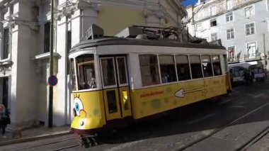 Lizbon, Portekiz - 14 Ekim 2019 Sünger Bob Kare Pantolon karakteriyle süslenmiş ayırt edici sarı tramvay Lizbon 'un dar kaldırımlı sokaklarında geleneksel beyaz binalarla çevrili. 