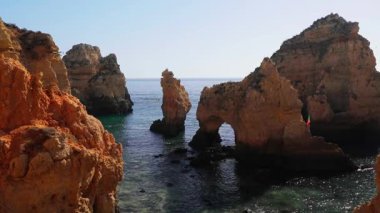 Algarve Portekiz 'deki Ponta da Piedade' deki ikonik altın kireç taşı oluşumlarının nefes kesici görüntüsü binlerce yıldır Atlantik dalgaları tarafından Lagos yakınlarındaki parlak gök mavisi sularına karşı şekillendirilen dramatik doğal deniz kemerleri ve mağaralar sergiliyor.