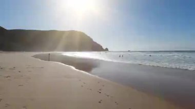 Portekiz sahillerinin nefes kesici panoramik manzarası. Altın kumlar, turkuaz sular, dramatik kırmızı uçurumlar ve düz soldan sağa kamera hareketiyle çekilen manzaralı kıyı yolları.