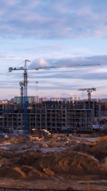 İnşaat alanı zaman çizelgesinde kule vinci ve konut geliştirme çalışmaları gündüz-akşam geçişi sırasında ele geçirildi. Gelişen ufuk çizgisi hareketine karşı dramatik bulut hareketi dinamik konut piyasası büyümesi ve kentsel genişleme gösteriyor