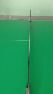 Profesyonel yeşil masa tenisi kortunda, kapalı alanda pinpon oynayan iki kişinin yakın çekim hareketleri.