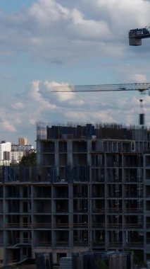 Kule vinçleri, müstakbel ev sahipleri ve emlak yatırım hayalleri için emlak geliştirme sürecini gösteren konut kompleksli beton çerçeve inşa ediyor.