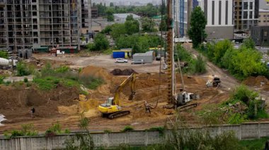 Vakıf sondaj kulesi konut inşaat sahasında yığınla sıkıcı işlemler gerçekleştirirken, kazıcı desteği konut yatırımı için emlak geliştirme ilerlemesi göstermektedir