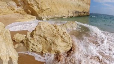 Portekiz 'in Algarve sahil şeridinin nefes kesici güzelliğini tecrübe edin. Orada dramatik altın kireçtaşı oluşumları kristal berraklığında turkuaz sularla buluşur ve el değmemiş kumlu plajlarla büyüleyici bir doğal cennet yaratır.