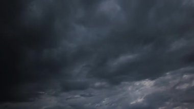Gökyüzünde hareket eden dramatik kara bulutların zamanı, dinamik fırtınalı havayı ve karamsar atmosferi gösteriyor