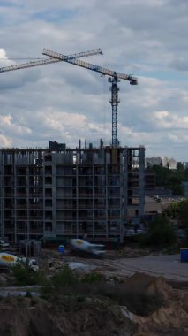 İnşaat alanı vinci, lüks konut yatırımları için gayrimenkul geliştirme sürecini gösteren konut kompleks beton çerçeve inşa ediyor.