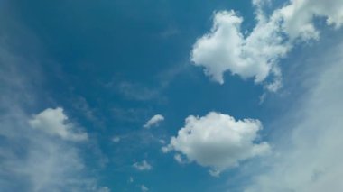 Pofuduk beyaz bulutların zamanı parlak mavi bir yaz gökyüzünde hareket ederek dinamik doğayı ve havadar atmosferi yakalıyor.