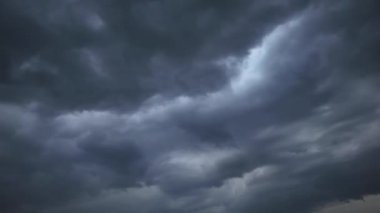 Gökyüzünde hareket eden kara fırtınalı bulutların dramatik zamanlaması. Bu sinematik ve karamsar arka plan doğanın uğursuz gücünü ve değişen havayı yakalar.
