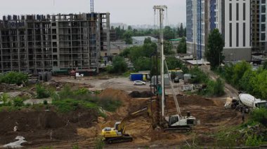 Sondaj kulesi, lüks konut yatırımları ve ev sahipliği fırsatları için gayrimenkul geliştirme ilerlemesini gösteren büyük konut şantiyesinde vakıf yığını çalışması yapıyor.