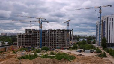 Yeni bir bina üzerinde çalışan vinçleri gösteren bir inşaat alanının zaman çizelgesi. Modern bir şehirde endüstriyel gelişim ve gayrimenkul gelişimi