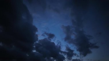 Karanlık gece bulutlarının sinematik zaman çizelgesi sakin ve huzurlu bir mavi gökyüzünü gözler önüne seriyor. Güzel ve gizemli bir hava değişimi.