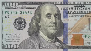 100 dolarlık banknotun Macro animasyonu. Diğer elementler yüzerken seri numaraları sırayla sayılıyor, yazıcı hatasını taklit ederek.