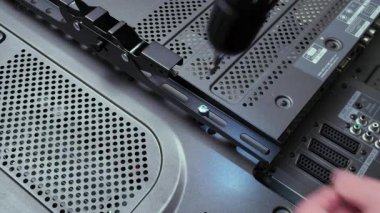 Ev kurulumu sırasında veya DIY onarımı sırasında duvara asma desteği takmak için matkap kullanan bir adamın yakın çekimi