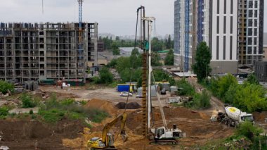 Gerçek zamanlı sondaj kulesi, konut geliştirme sahasında lüks konut yatırım fırsatları için devam eden gayrimenkul ilerlemesini gösteren vakıf yığını inşaatını gerçekleştirir.