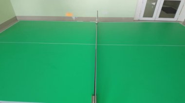 Masa tenisinde pinpon topunun raket vuruşundan sonra ağa vuruşunun video görüntüleri. Turuncu top kapalı alanda spor yaparken ağı geçemiyor