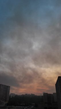 İHA saldırılarının ardından gün doğumunda Kyiv 'in üzerine kara duman sürüklendi. Konut ve sanayi bölgelerinde yangınlar çıktı. Dramatik şehir silüeti, yaz sabahı.