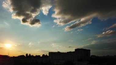 Şehir günbatımı zaman çizelgesi kentsel ufuk çizgisinin siluetlerini, parlayan bulutları, canlı gökyüzünü ve gün ışığından alacakaranlığa huzurlu geçişi gösteriyor.