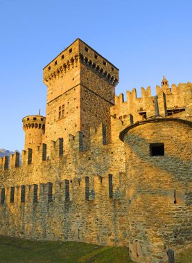 Gün batımında Aosta Vadisi 'ndeki Fenis Kalesi. Fenis Kalesi Aosta Vadisi 'ni koruyan kalelerden biri. İtalya 'daki Aosta Vadisi ortaçağ kaleleriyle dolu..