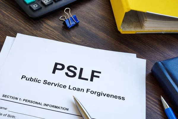 Papers foe Public Service Loan Forgiveness PSLF on wooden surface.