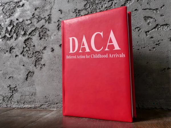 Book Deferred Action for Childhood Arrivals DACA law near wall.