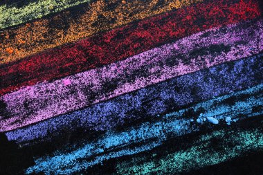 Multicolored background with lines from colored crayons on the blackboard.