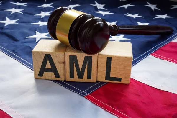 Flag of the USA, cubes with inscription AML Anti money laundering and gavel.