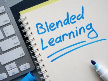 Yazılı harmanlanmış öğrenimi olan bir klavye ve defter.