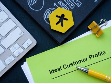 İdeal müşteri profili ve klavyesi olan kağıt yığını.