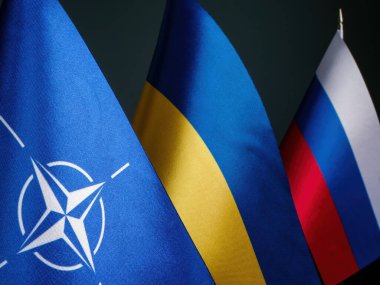 KYIV, UKRAINE - Nisan 04, 2023 NATO, Ukrayna ve Rusya Bayrakları. Yazı.