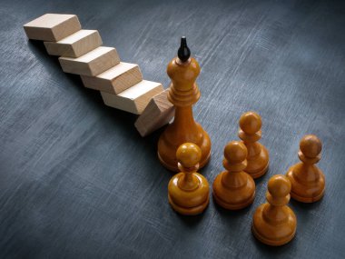 Satranç kralı düşen blokları liderlik ve kriz yönetiminin sembolü olarak tutuyor..