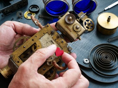 Ustanın elleri mekanik bir robot ve bir kalp tutuyor..