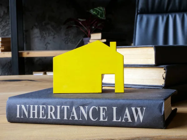 stock image Book inheritance law and model of house on it.