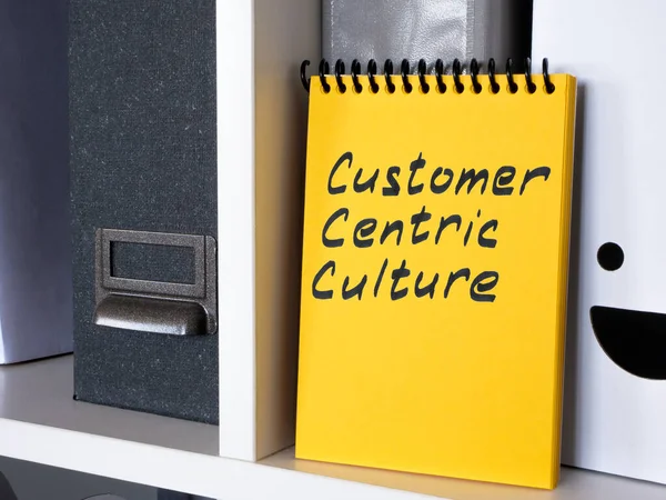 A notepad with an inscription Customer centric culture is on the shelf.