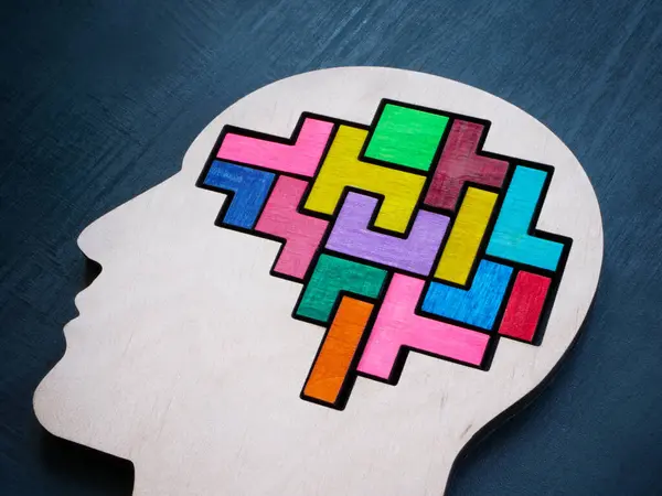 A head with a multi-colored puzzle inside as a symbol of autism or neurodiversity.