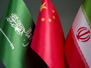 Yakınlarda Suudi Arabistan, Çin ve İran bayrakları.