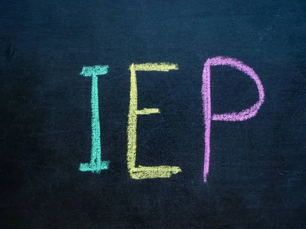 Individualized Education Program IEP written in chalk on a blackboard.