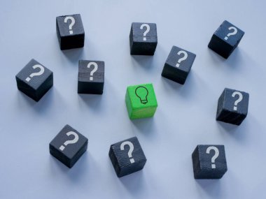 Soru işaretli küpler ve bir fikir veya cevap kavramı olarak bir ampul ile bir.