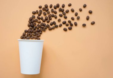 Kağıt bardak ve kavrulmuş kahve çekirdeği. Modern sanat konsepti.