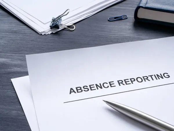 Absence reporting documents and a notepad.