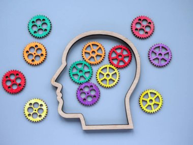 Autism and neurodiversity concept. Head and wooden colored gears. clipart