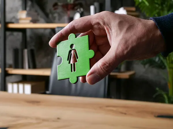 Gender equality at work. Workplace and puzzle piece with a female figure.