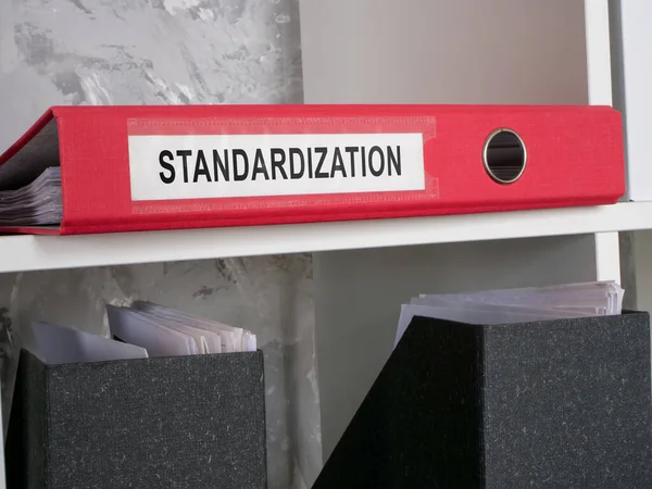 A folder with documents about standardization on shelf.