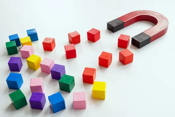Talented employee or customer acquisition concept. The magnet attracts red cubes.