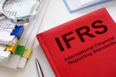 Bir yığın kağıt ve kitap IFRS Uluslararası Finansal Raporlama Standartları.