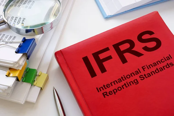Bir yığın kağıt ve kitap IFRS Uluslararası Finansal Raporlama Standartları.