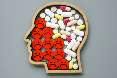 Depresyon konsepti için psikiyatrik tedavi. Kafa, negatif duygu simgeleri ve haplar..